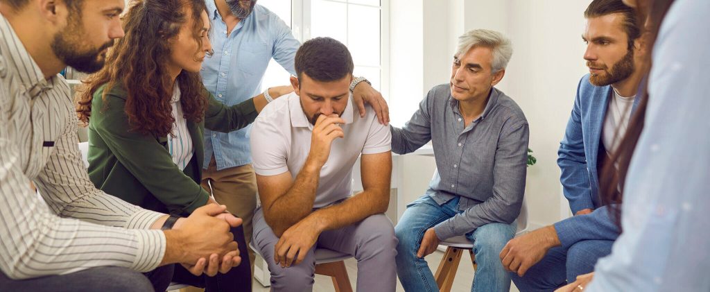 Un homme bénéficie du soutien de ses collègues suite à un événement traumatique.